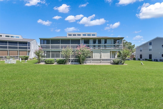 back of house with a sunroom, a yard, and a balcony