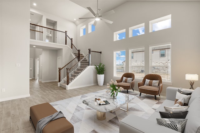 living room featuring a wealth of natural light, light hardwood / wood-style floors, and a high ceiling