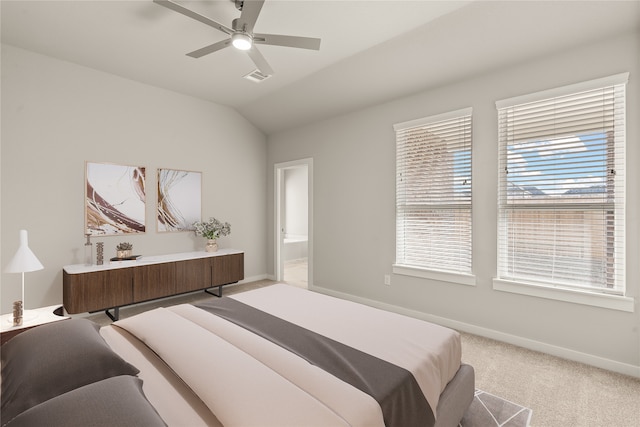 carpeted bedroom featuring ensuite bathroom, ceiling fan, multiple windows, and lofted ceiling