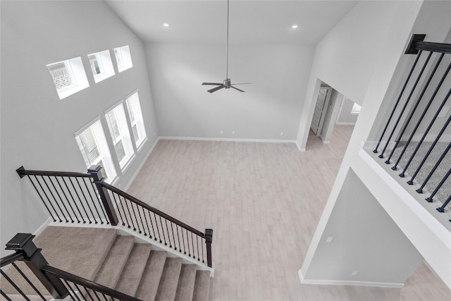 staircase featuring hardwood / wood-style flooring and a high ceiling