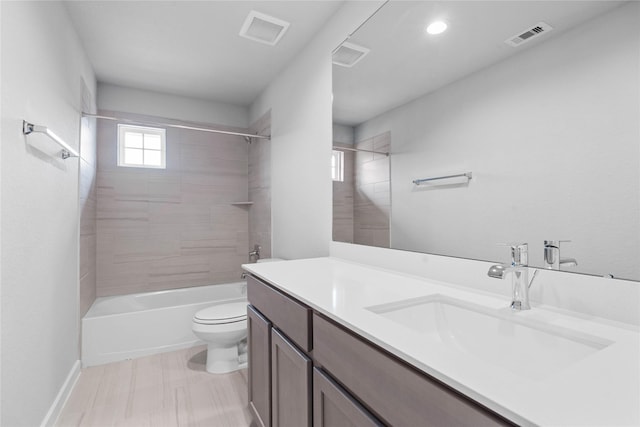 full bathroom with tiled shower / bath combo, vanity, and toilet