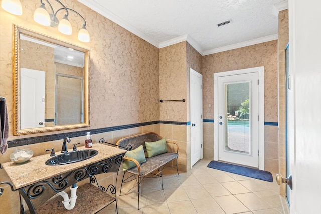 bathroom with sink, ornamental molding, a textured ceiling, and tile patterned floors