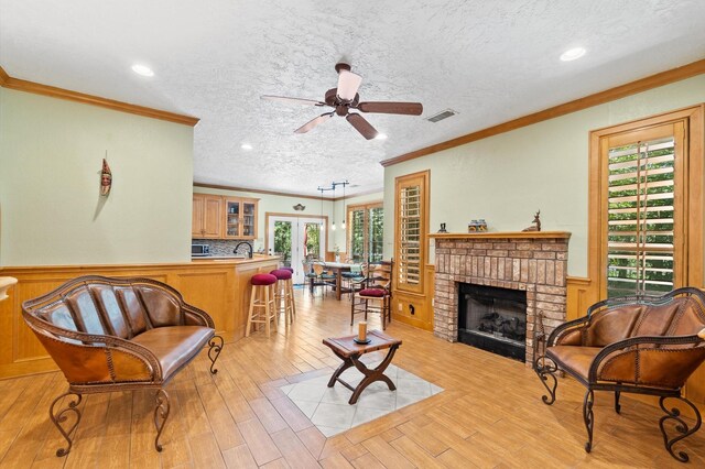 living room with a fireplace, plenty of natural light, and ceiling fan