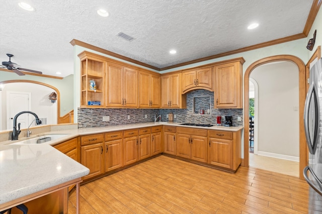 kitchen with sink, light wood-type flooring, backsplash, and ceiling fan