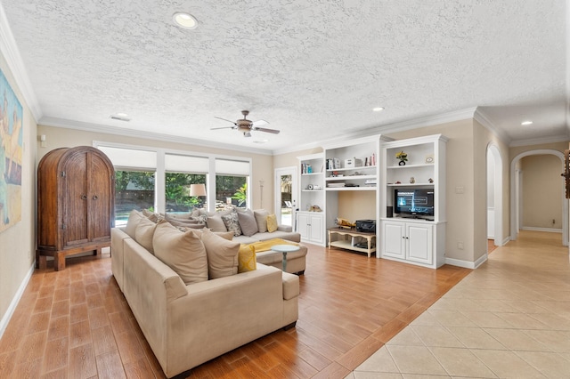 living room featuring a textured ceiling, light hardwood / wood-style flooring, and crown molding