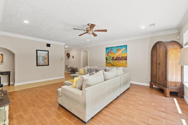 living room with light hardwood / wood-style floors, crown molding, ceiling fan, and a textured ceiling