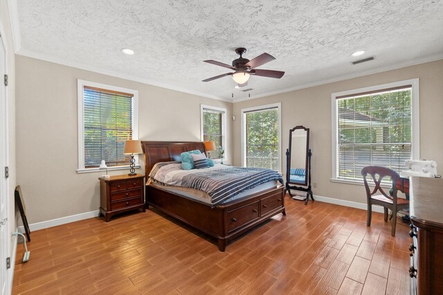 bedroom featuring ceiling fan, crown molding, and multiple windows