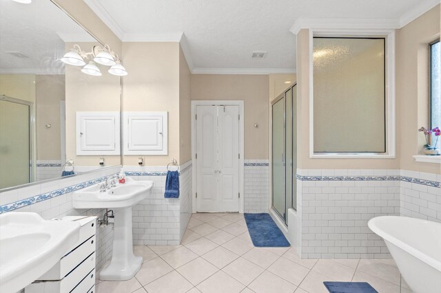 bathroom with shower with separate bathtub, crown molding, tile patterned floors, a textured ceiling, and tile walls