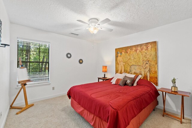 carpeted bedroom featuring a textured ceiling and ceiling fan