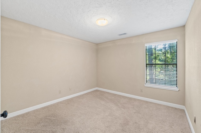 carpeted spare room featuring a textured ceiling