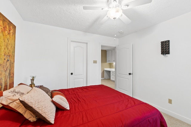 carpeted bedroom featuring ceiling fan and a textured ceiling