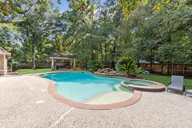 view of swimming pool featuring a yard, an in ground hot tub, and a patio