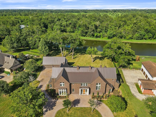 drone / aerial view with a water view and a forest view