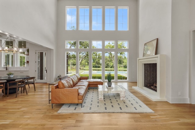 living room with light hardwood / wood-style floors and a high ceiling