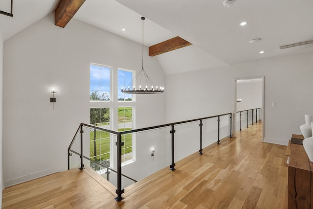 interior space featuring high vaulted ceiling, a notable chandelier, beamed ceiling, and light hardwood / wood-style flooring