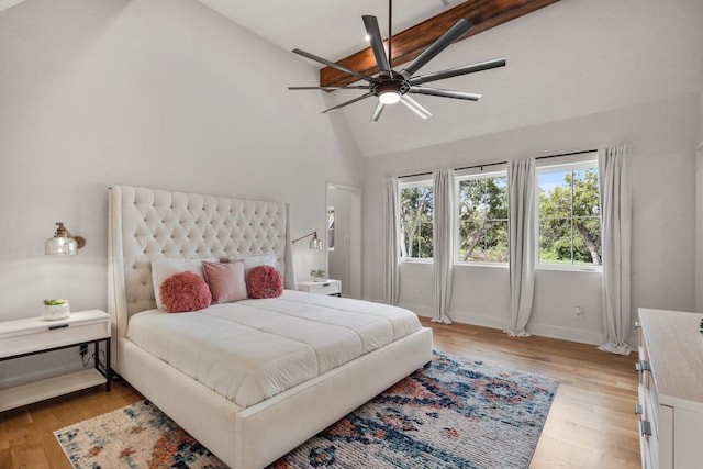 bedroom featuring light wood-type flooring, beam ceiling, high vaulted ceiling, and ceiling fan