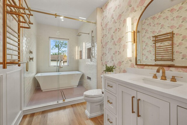 bathroom featuring hardwood / wood-style flooring, toilet, a tile shower, and vanity