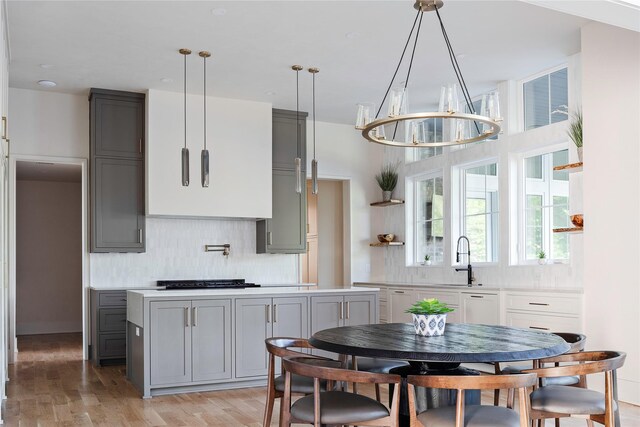 kitchen featuring tasteful backsplash, gray cabinetry, and light hardwood / wood-style floors