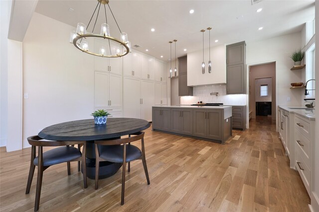 interior space featuring backsplash, a center island, light hardwood / wood-style floors, and gray cabinets