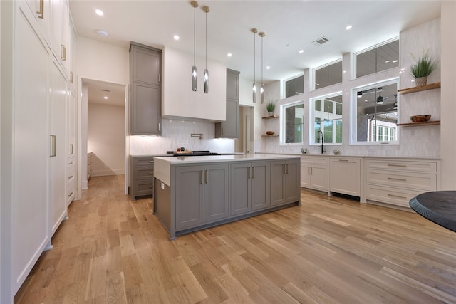 kitchen with a center island, gray cabinetry, and light hardwood / wood-style floors