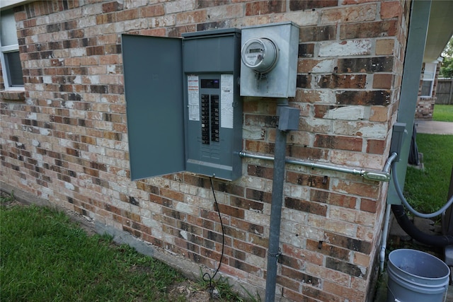 exterior details with electric meter, brick siding, and electric panel