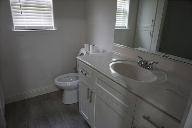 bathroom with baseboards, toilet, and vanity