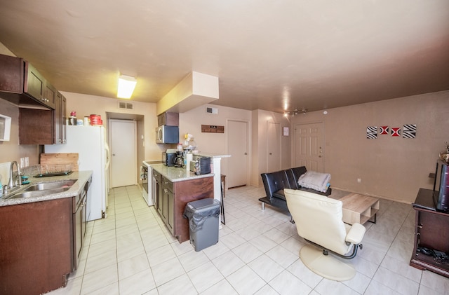 kitchen with sink, light stone countertops, and light tile patterned floors