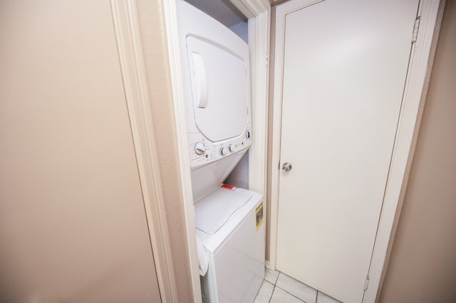 laundry room featuring light tile patterned floors and stacked washer / dryer