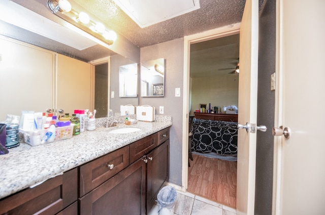 bathroom with tile patterned floors, a textured ceiling, vanity, and ceiling fan