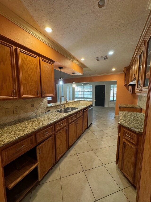 kitchen featuring sink, light stone counters, tasteful backsplash, light tile patterned floors, and pendant lighting