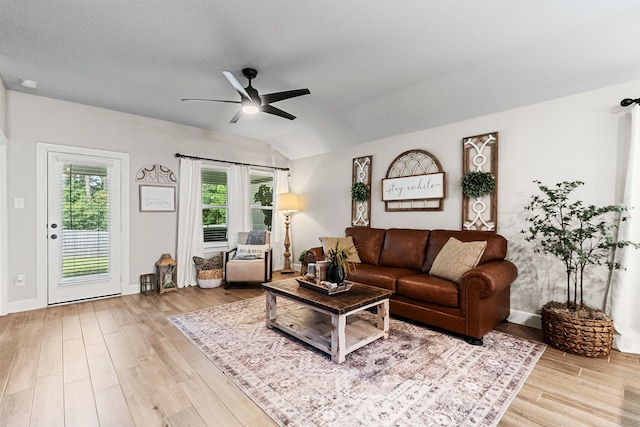 living room featuring ceiling fan, vaulted ceiling, and light hardwood / wood-style floors