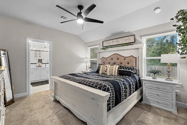 bedroom featuring light colored carpet, ensuite bathroom, and multiple windows