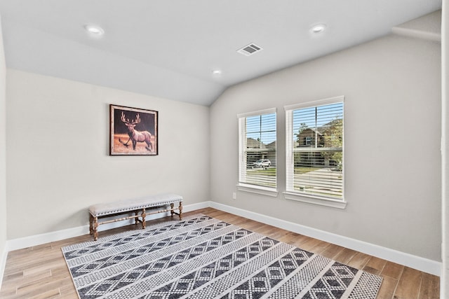 living area with light wood-type flooring and lofted ceiling