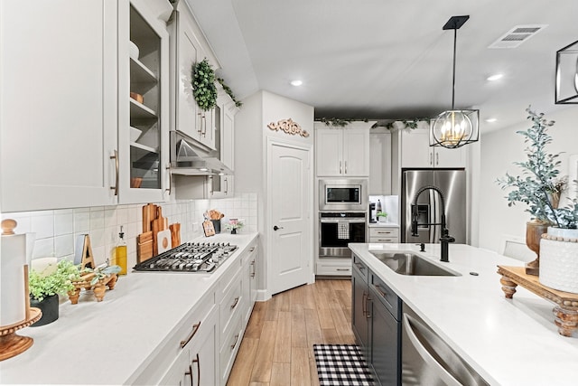 kitchen featuring a notable chandelier, white cabinets, light hardwood / wood-style floors, decorative light fixtures, and stainless steel appliances