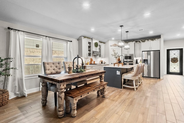 dining space featuring light wood-type flooring and an inviting chandelier