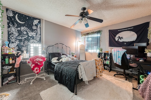 bedroom with a textured ceiling, carpet floors, and ceiling fan