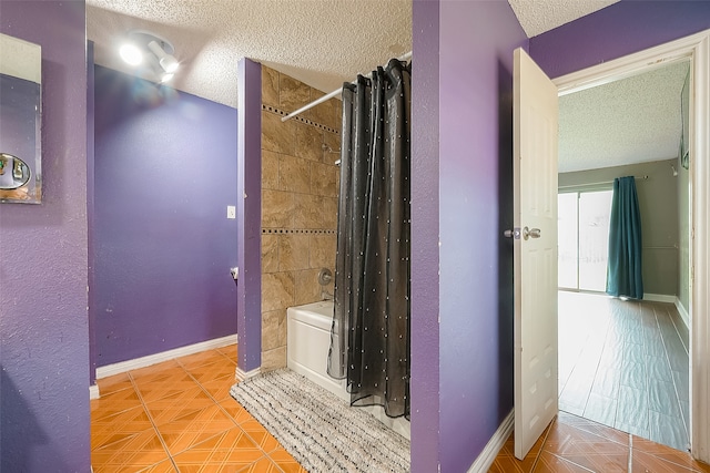 bathroom with tile patterned flooring, a textured ceiling, and shower / bath combination with curtain