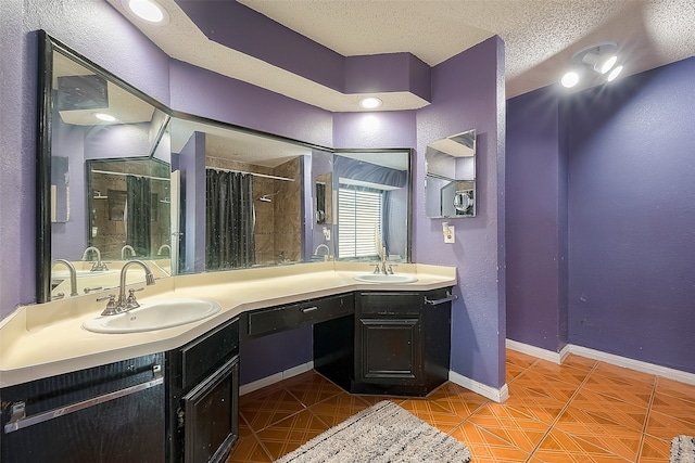 bathroom featuring a textured ceiling, double vanity, a tile shower, and tile patterned floors