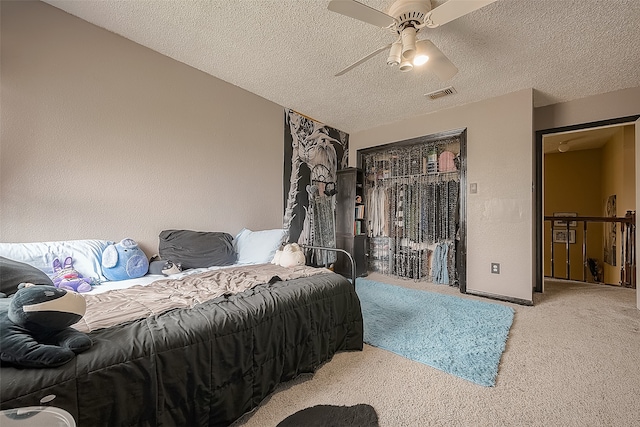 bedroom featuring ceiling fan, a textured ceiling, and carpet