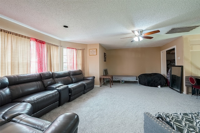 living room featuring ceiling fan, a textured ceiling, and carpet floors