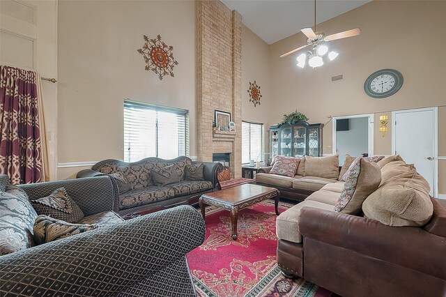 living room featuring ceiling fan, high vaulted ceiling, and a brick fireplace