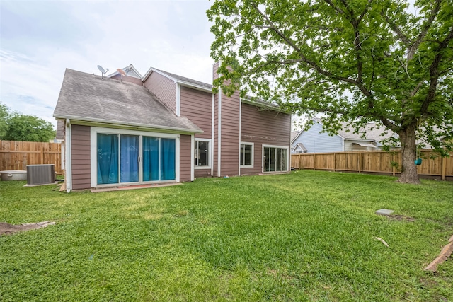 rear view of house featuring central AC and a yard