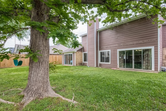 rear view of house featuring a yard