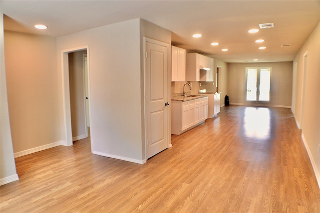 kitchen featuring french doors, white cabinets, sink, and light hardwood / wood-style flooring