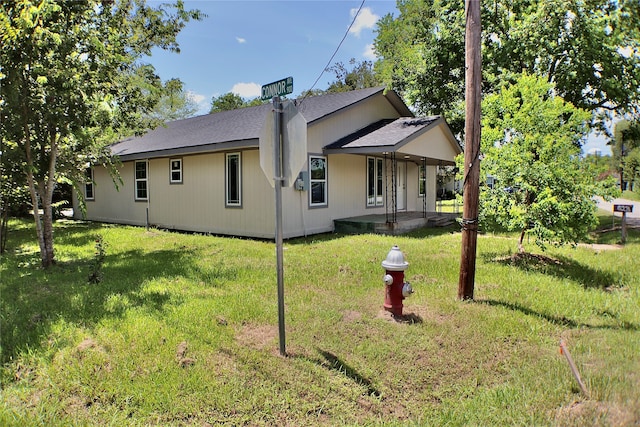 rear view of property featuring a yard