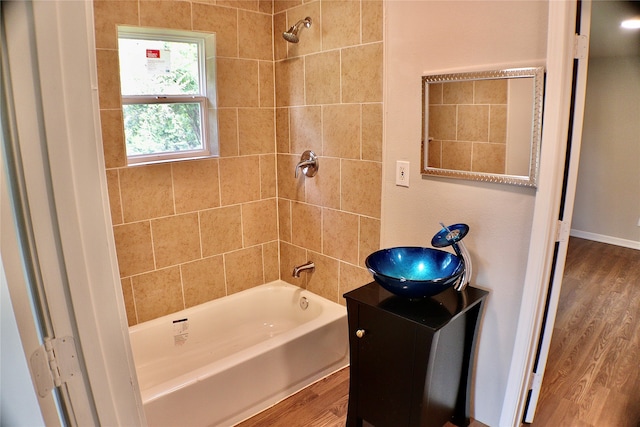 bathroom featuring tiled shower / bath, wood-type flooring, and vanity