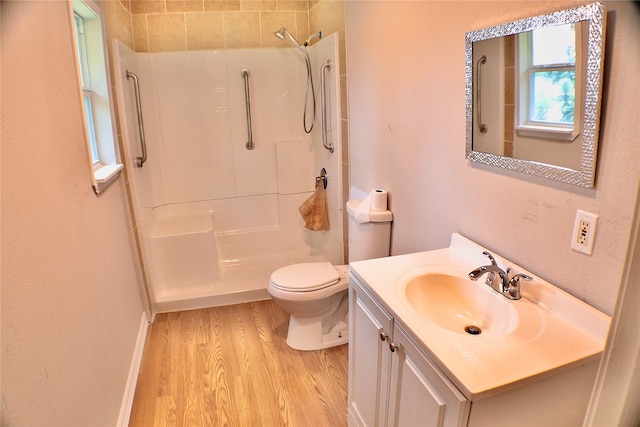 bathroom with tiled shower, vanity, and toilet