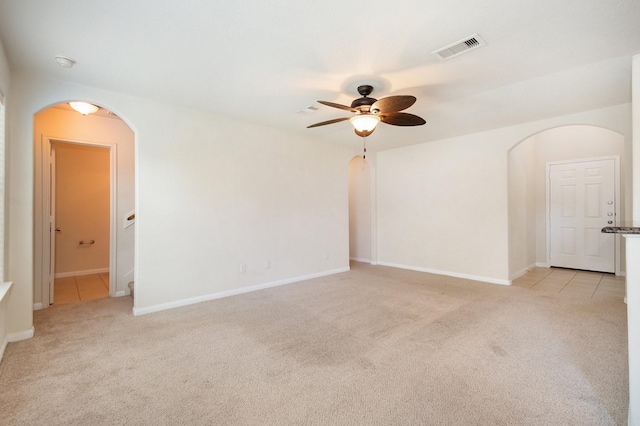 empty room featuring ceiling fan and light colored carpet