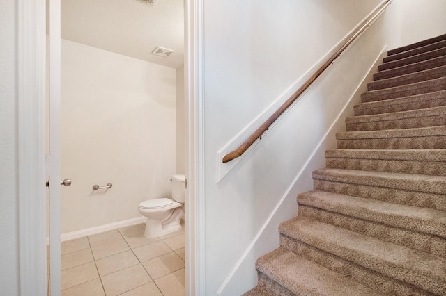 staircase featuring visible vents, baseboards, and tile patterned floors