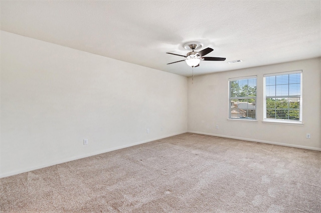 unfurnished room with visible vents, a ceiling fan, light carpet, a textured ceiling, and baseboards